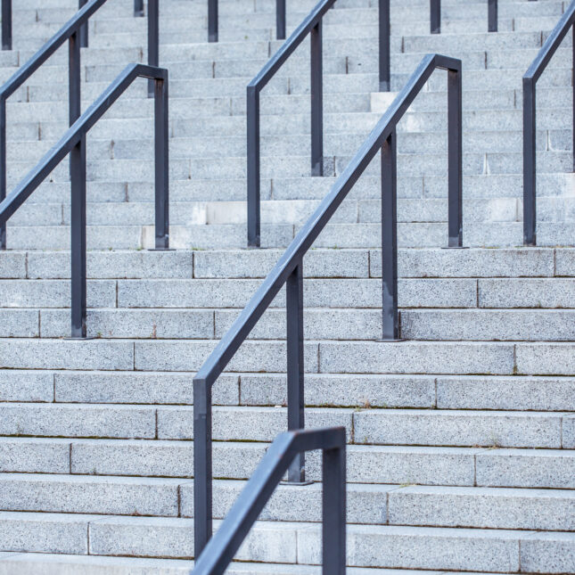 Photograph of very tall, intimidating concrete stairs and railings, suggestive of a university campus that is not welcoming