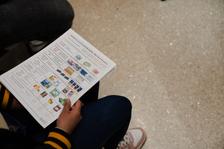 A GROW Clinic Teaching Kitchen participant holds a flyer with information about iron-rich foods in the Teaching Kitchen at Boston Medical. -- health coverage from STAT